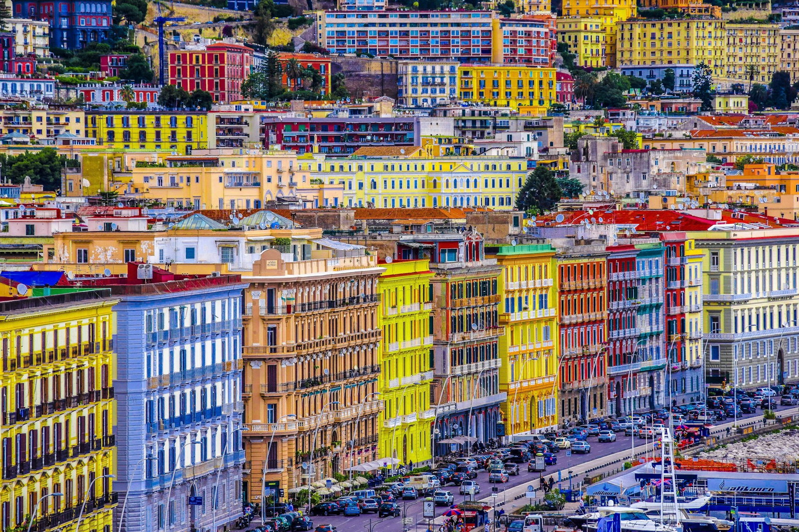 Rainbow coloured port filled with vibrant buildings stacked close to each other and lots of cars