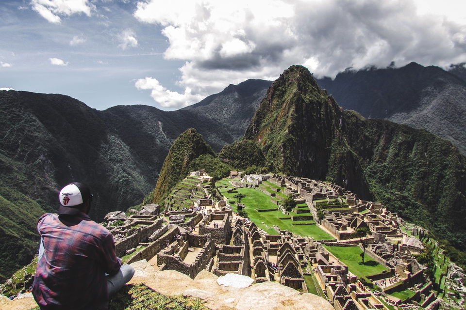 Man looking out over mountains and ruins