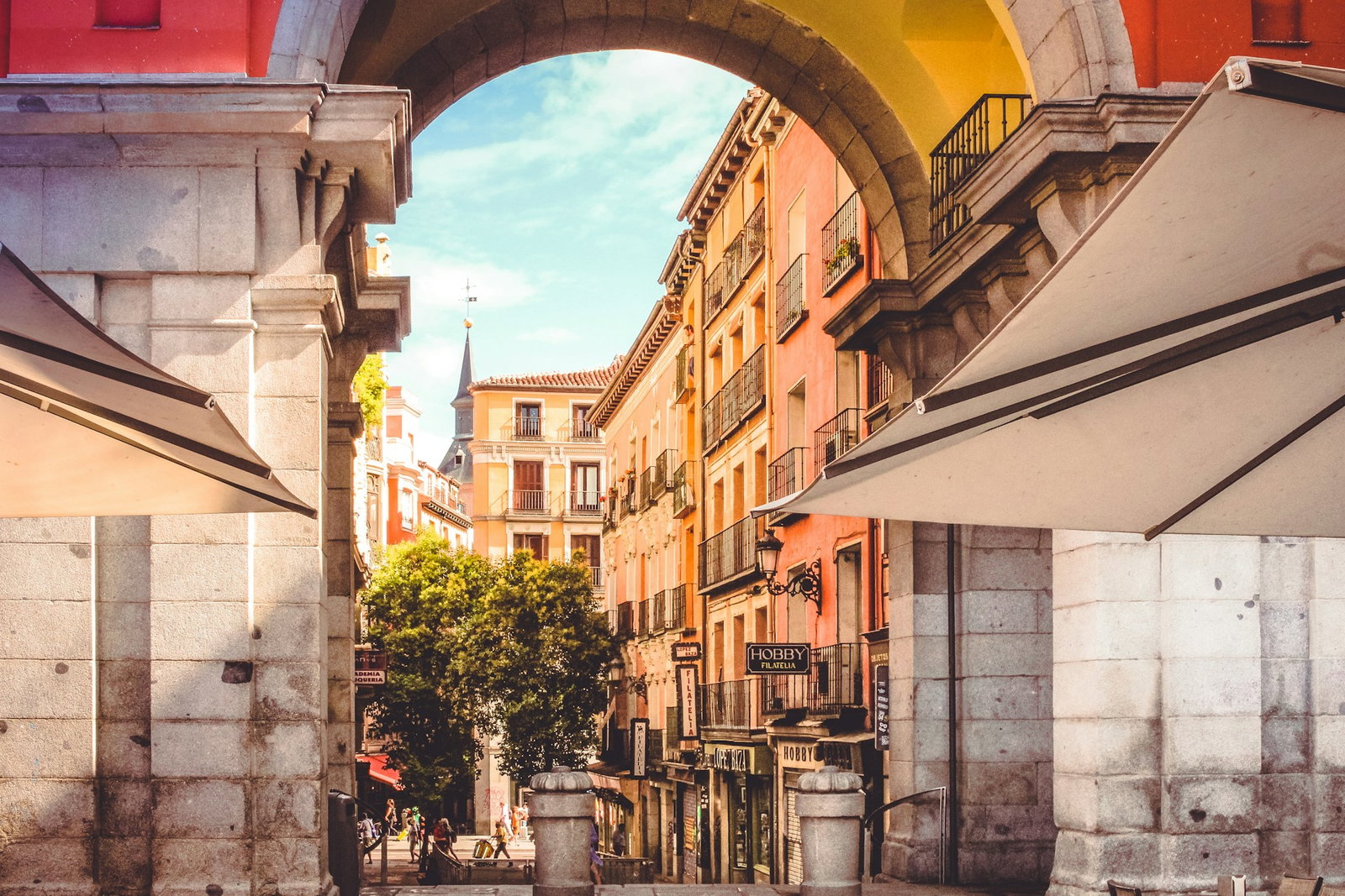 Colourful backstreet in Seville with archway and bright buildings on sunny day
