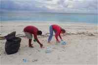 Two volunteers picking up rubbish on a beach