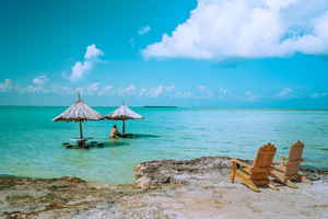 Traveller sitting in ocean on beach San Pedro, Belize