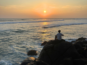 Traveller watching the sunset at Mirissa beach in Sri lanka