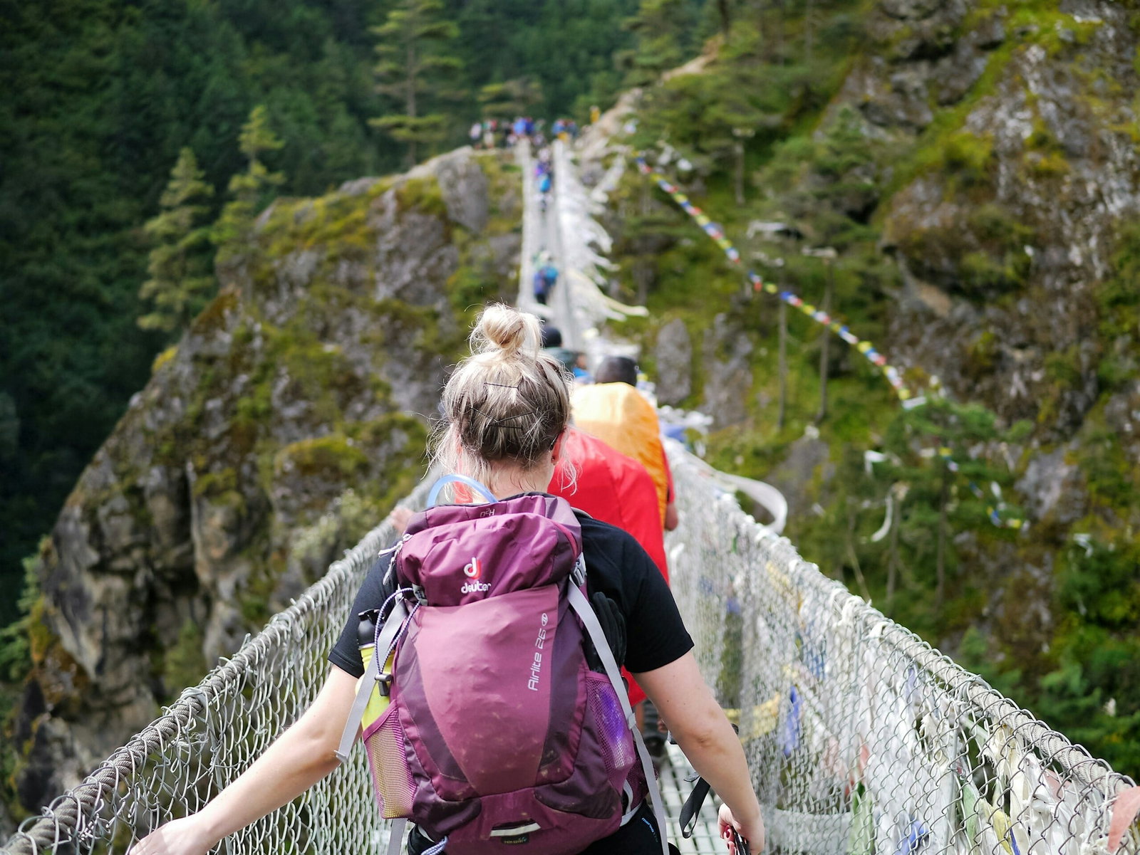 Group traveller walking over bridge in Nepal Backpacking