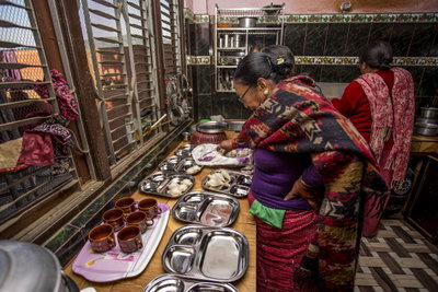 Two ladies preparing food in a kitchen