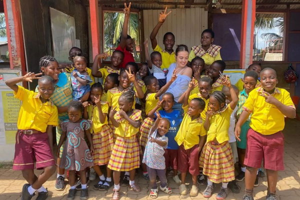 Volunteer in group photo with children in ghana on childcare project