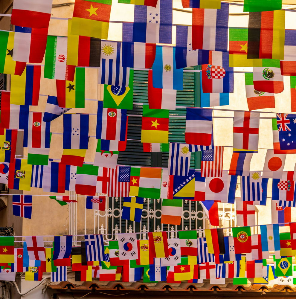 Country flags hanging from string above a street