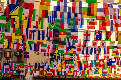 Country flags hanging from string above a street