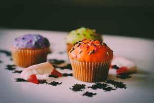 Cupcakes with frosting and sprinkles, candy teeth, and fake spiders