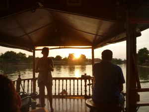 Two travellers sitting in a hut on the water in Thailand
