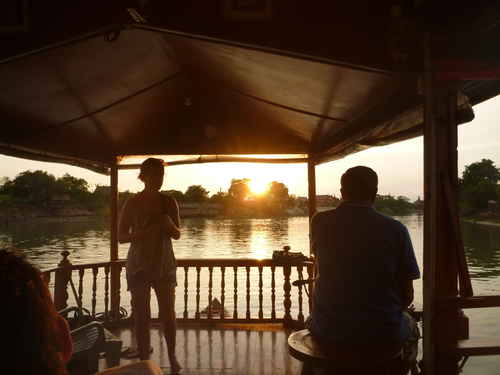 Two travellers sitting in a hut on the water in Thailand