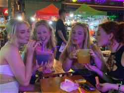 Girls drinking at bar on Thai Adventure tour