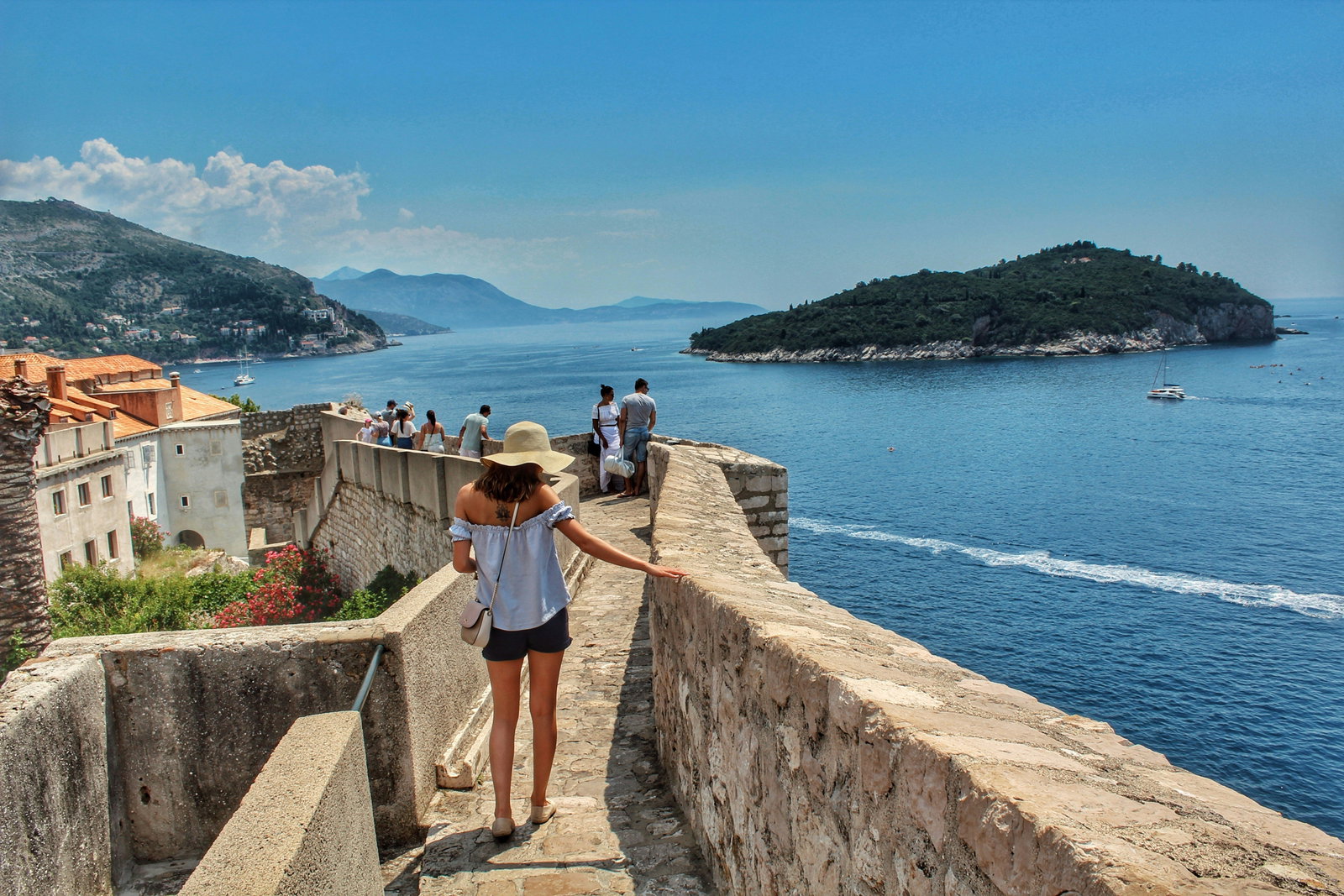 Lady walking along the wall in Croatia