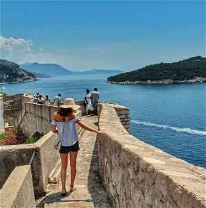 Lady walking along the wall in Croatia