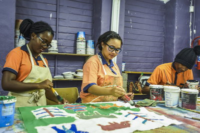 Three people painting in an art studio 