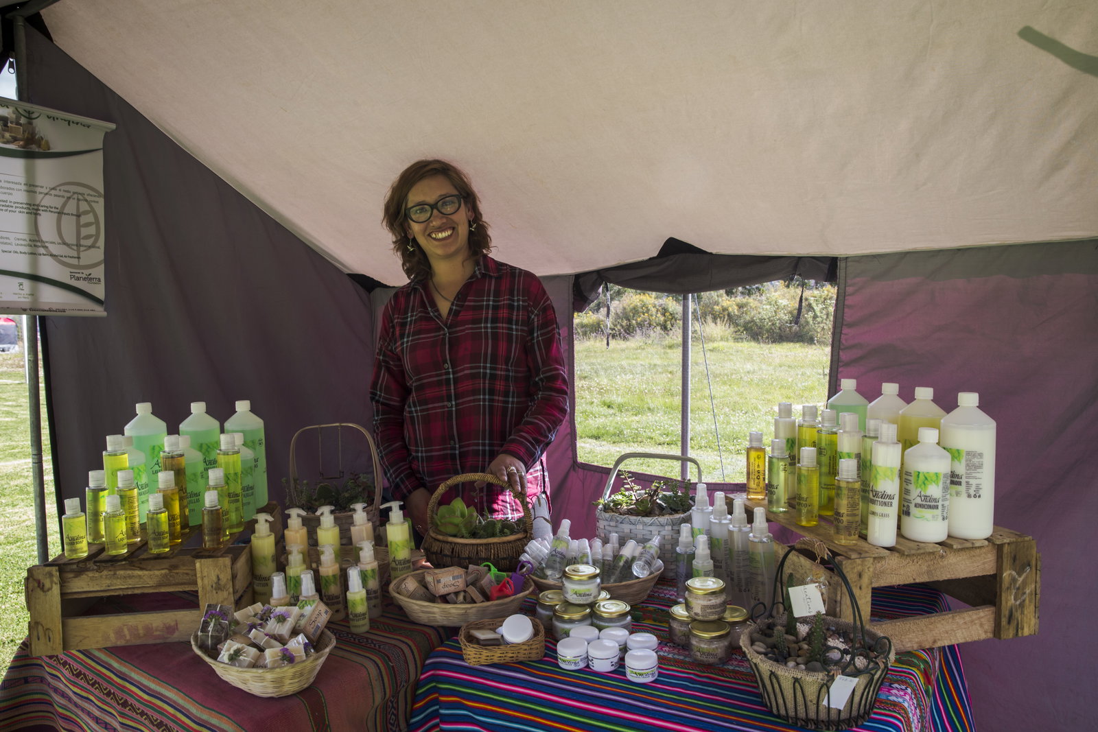 Women standing at a market stall with soaps and detergents handmade
