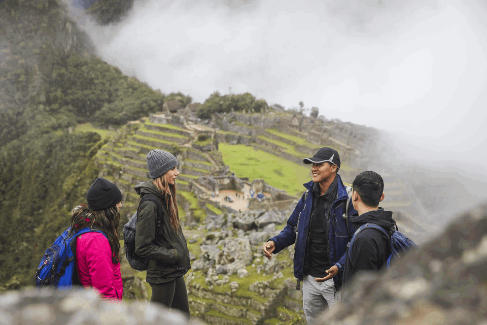 group travellers at machu picchu inca trek with tour guide