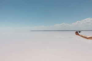 Person holding sunglasses on a beach