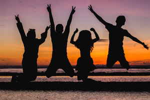 Group jumping in front of a sunset