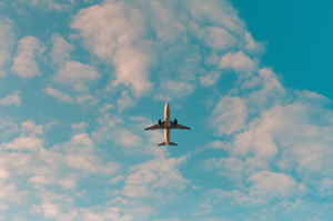 Plane in blue sky with soft clouds