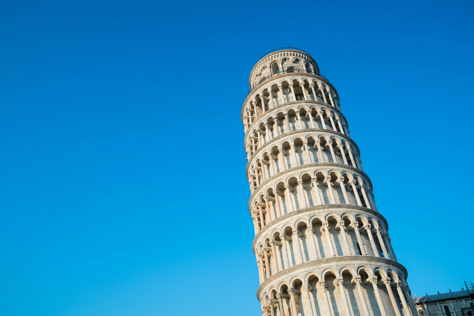 Clear blue sky with leaning tower in the sky with columns built around it