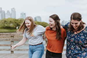 Three travellers walking with their arms around each other