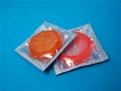 Two condoms in their wrappers on a blue background