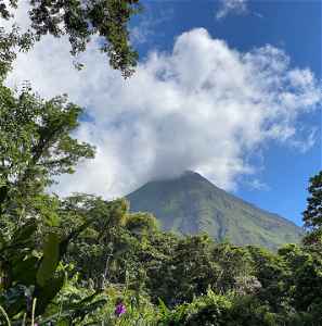 Arenal volcano smouldering with smoke amongst dense jungle