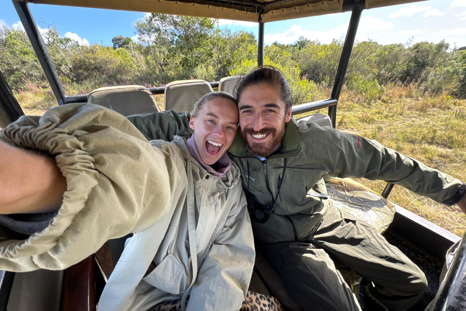Travellers volunteering on a safari in South Africa, sat in back on jeep