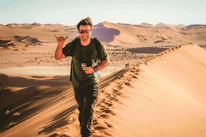 Group traveller walking along Sand Dunes in Africa