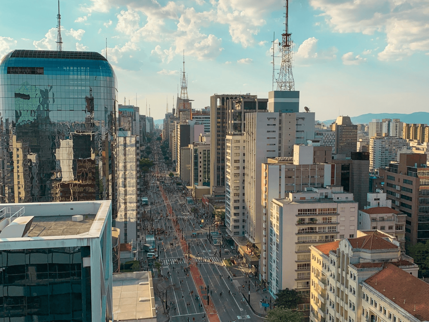 Cityscape with modern skyscrapers and busy public streets on cloudy but sunny day