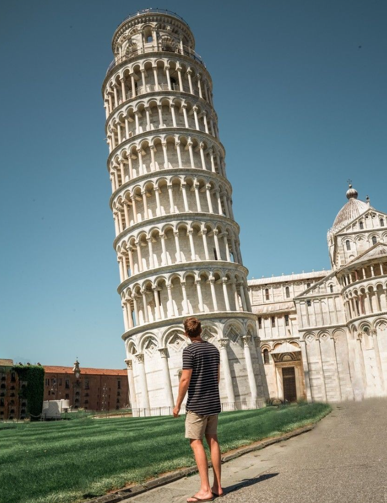 Traveller stood looking up at the leaning tower of Pisa