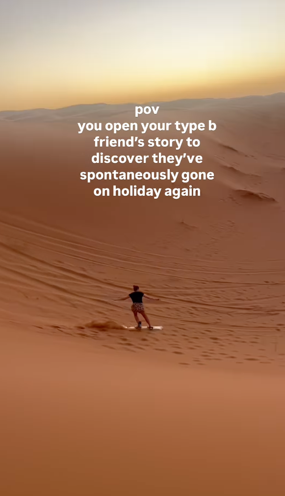 Traveller sandboarding down dune in the Sahara Desert
