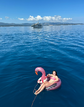 Traveller floating on pink flamingo inflatable in Croatian sea