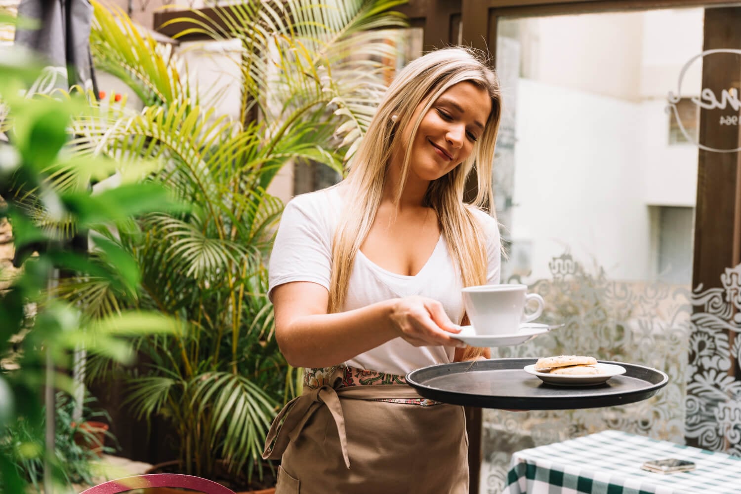 Woman on paid working holiday serving drinks in cafe