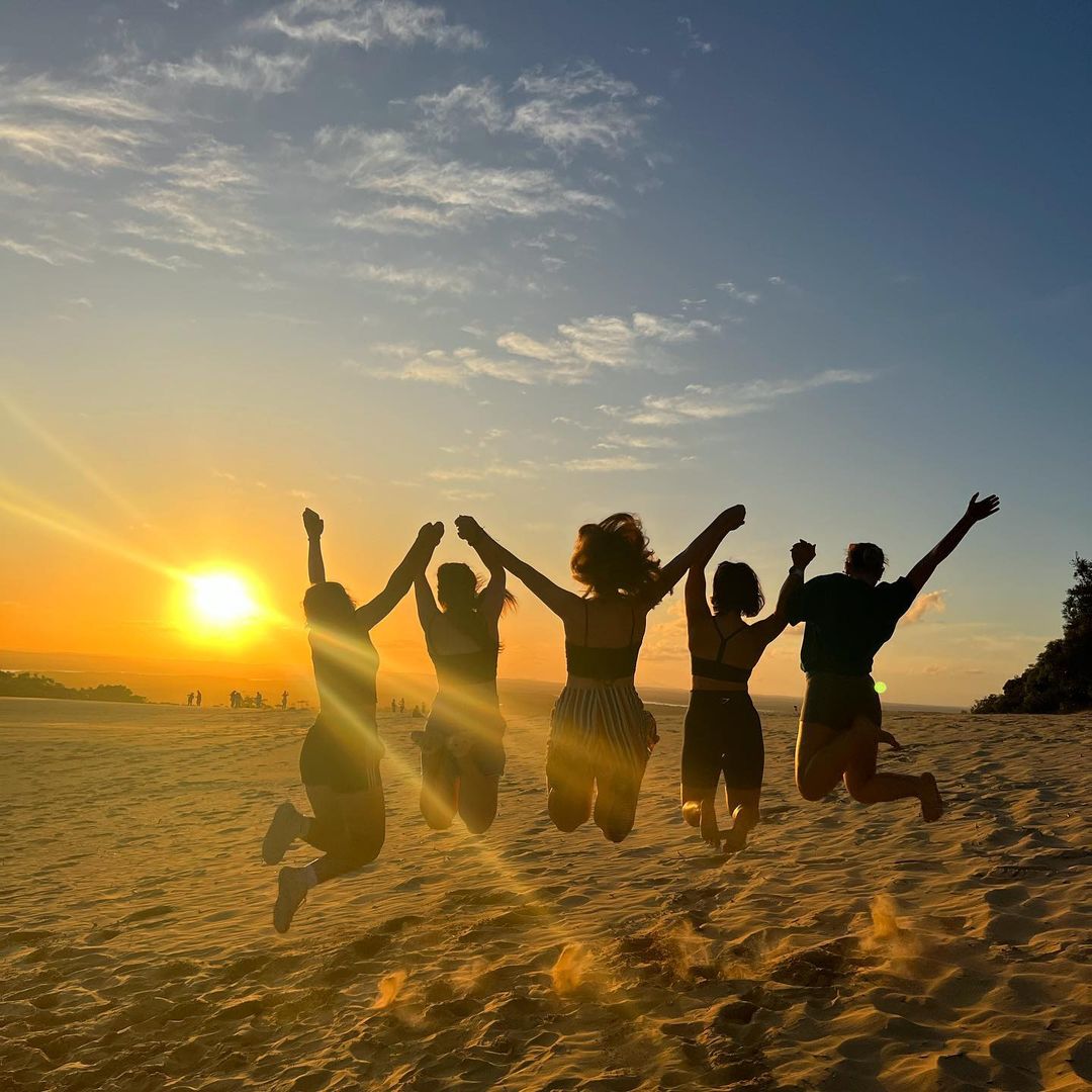 Group jumping on Rainbow Beach, Australia