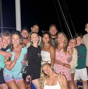 Travellers on sailing boat with drinks in hand ready for a night out