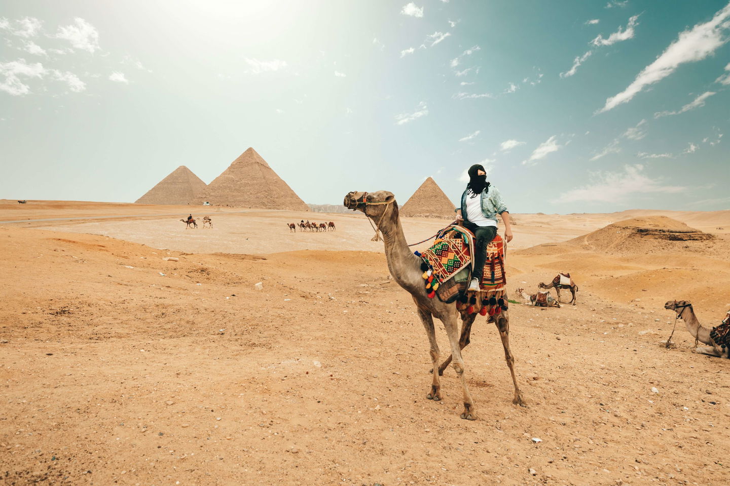 Person sat on camel in front of Great Pyramid of Giza in Egypt