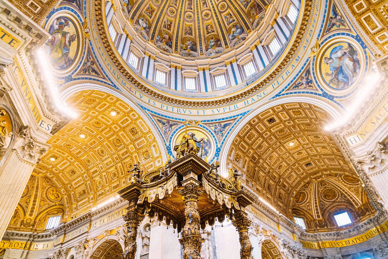 Golden dome ceilings adorned with Renaissance paintings and Latin calligraphy, golden pillars in the centre