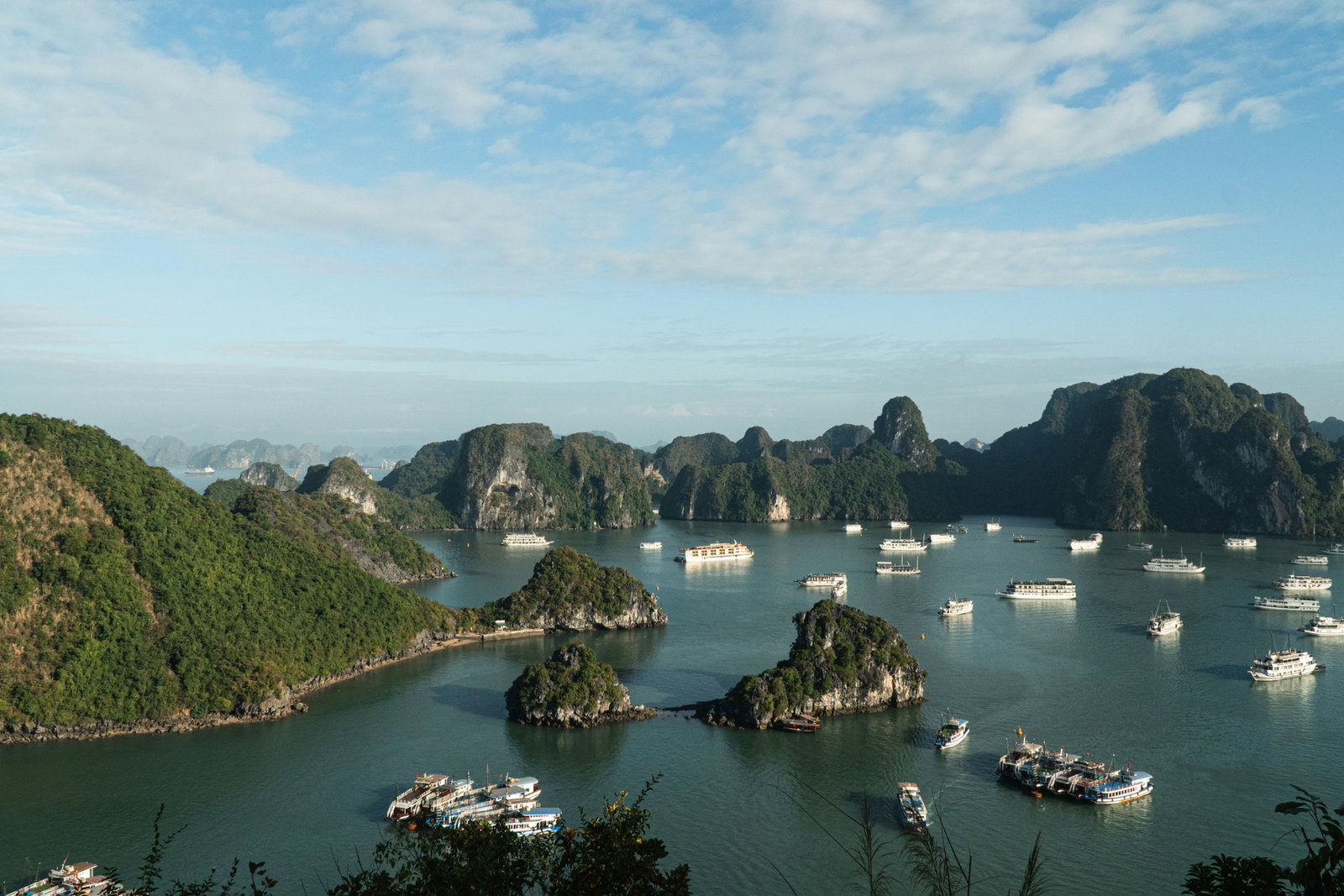 Boats sitting in Ha Long Bay with surrounding islands