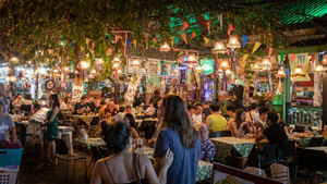 Two travellers looking at an outdoor seating area at a restauraunt on Khao San road
