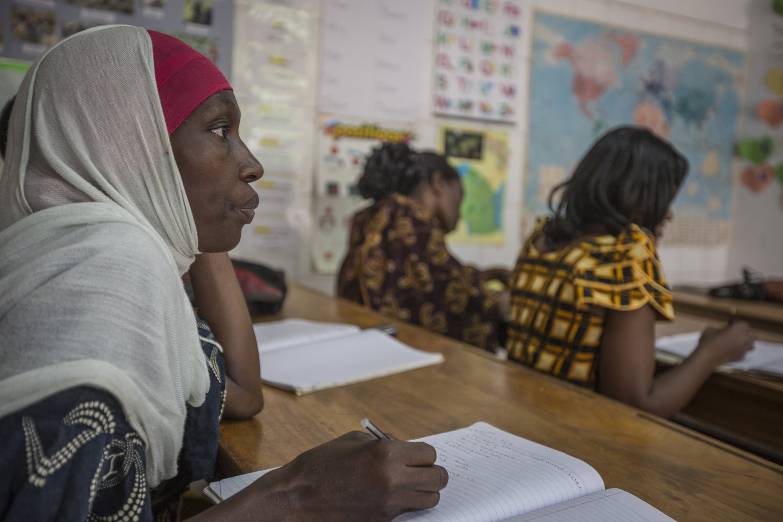 Students in a classroom writing in notebooks