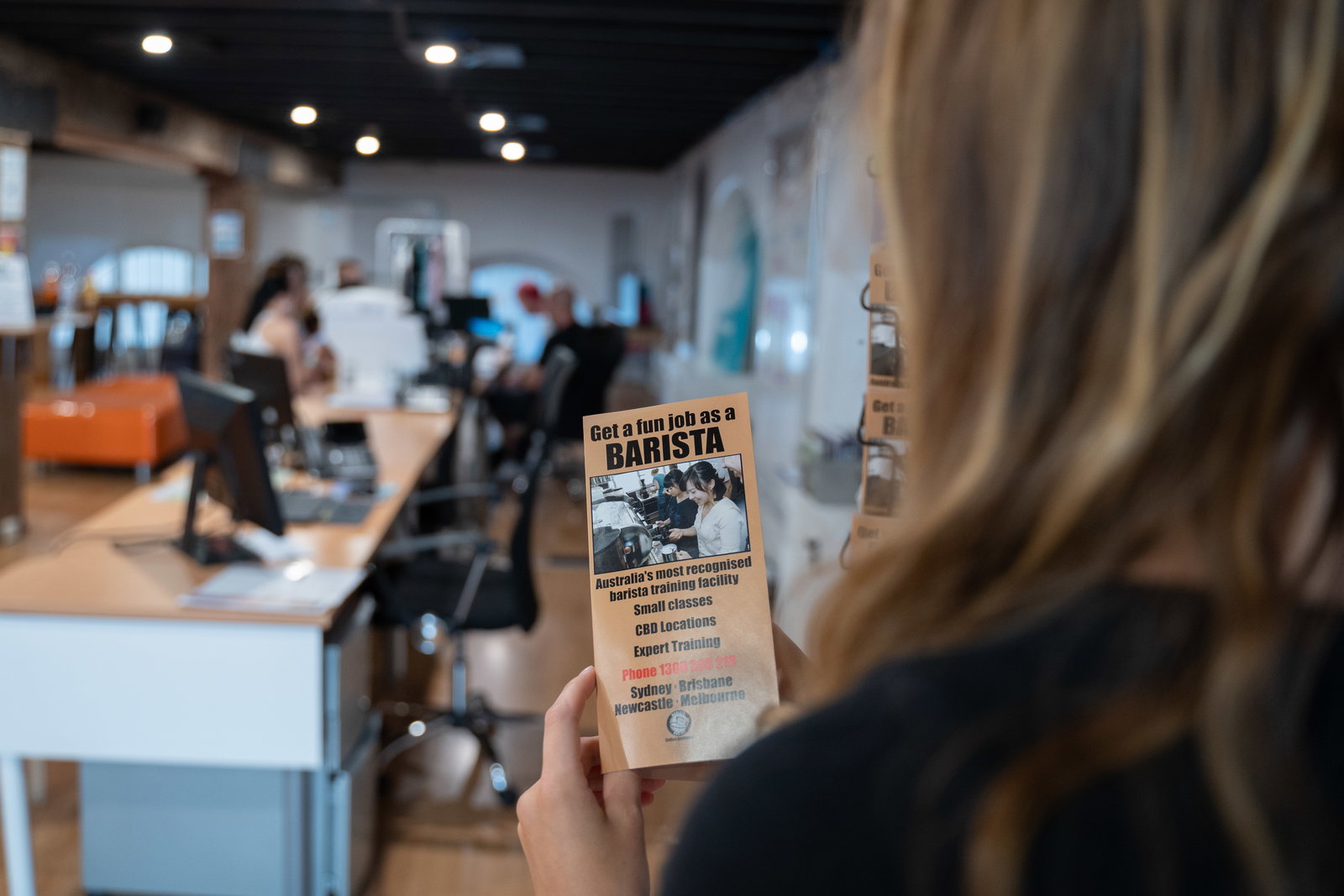 Person looking at barista brochure in Sydney job office