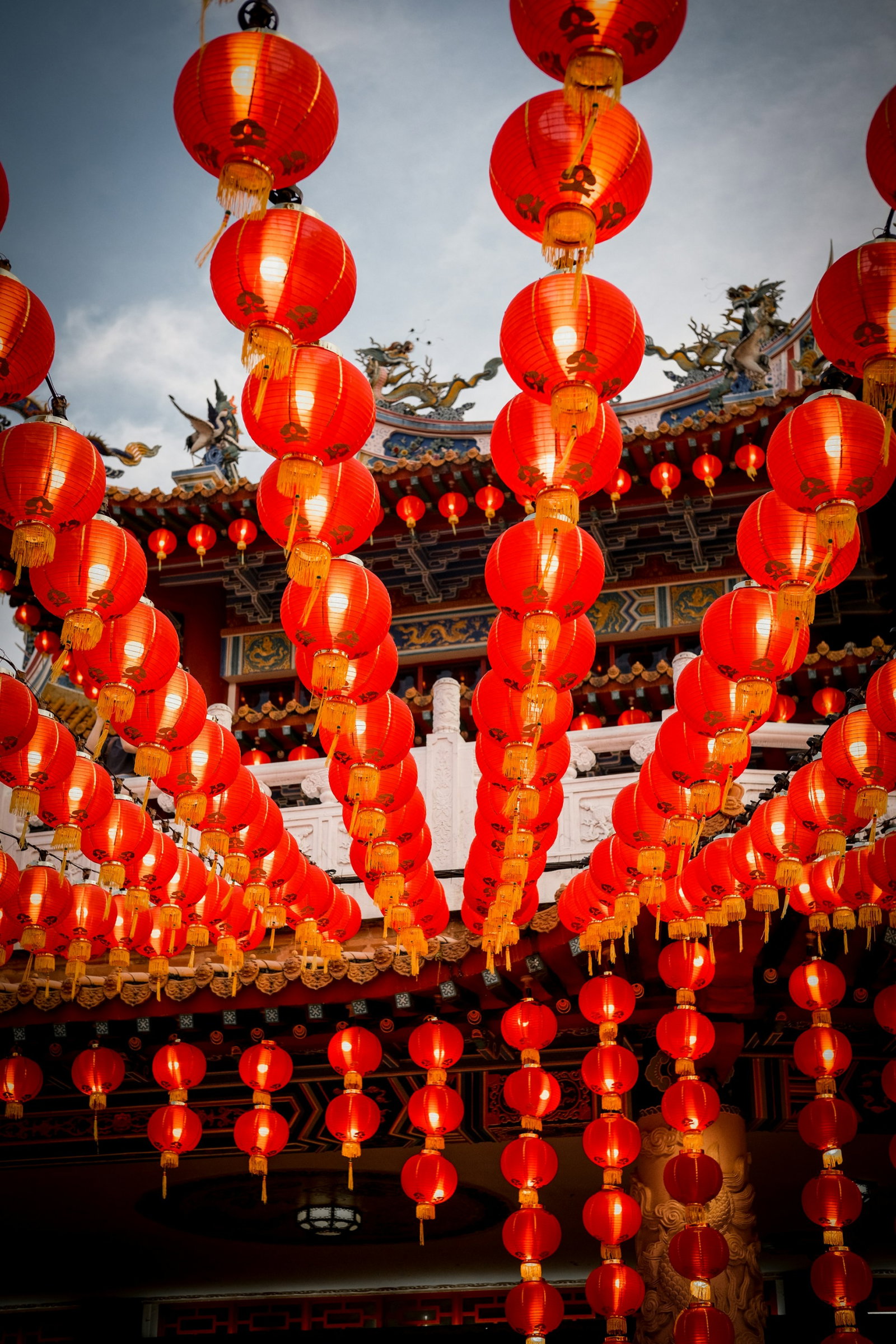 Row of Chinese red paper lanterns at a local temple with dragon on the pagoda roof, located in Malaysia