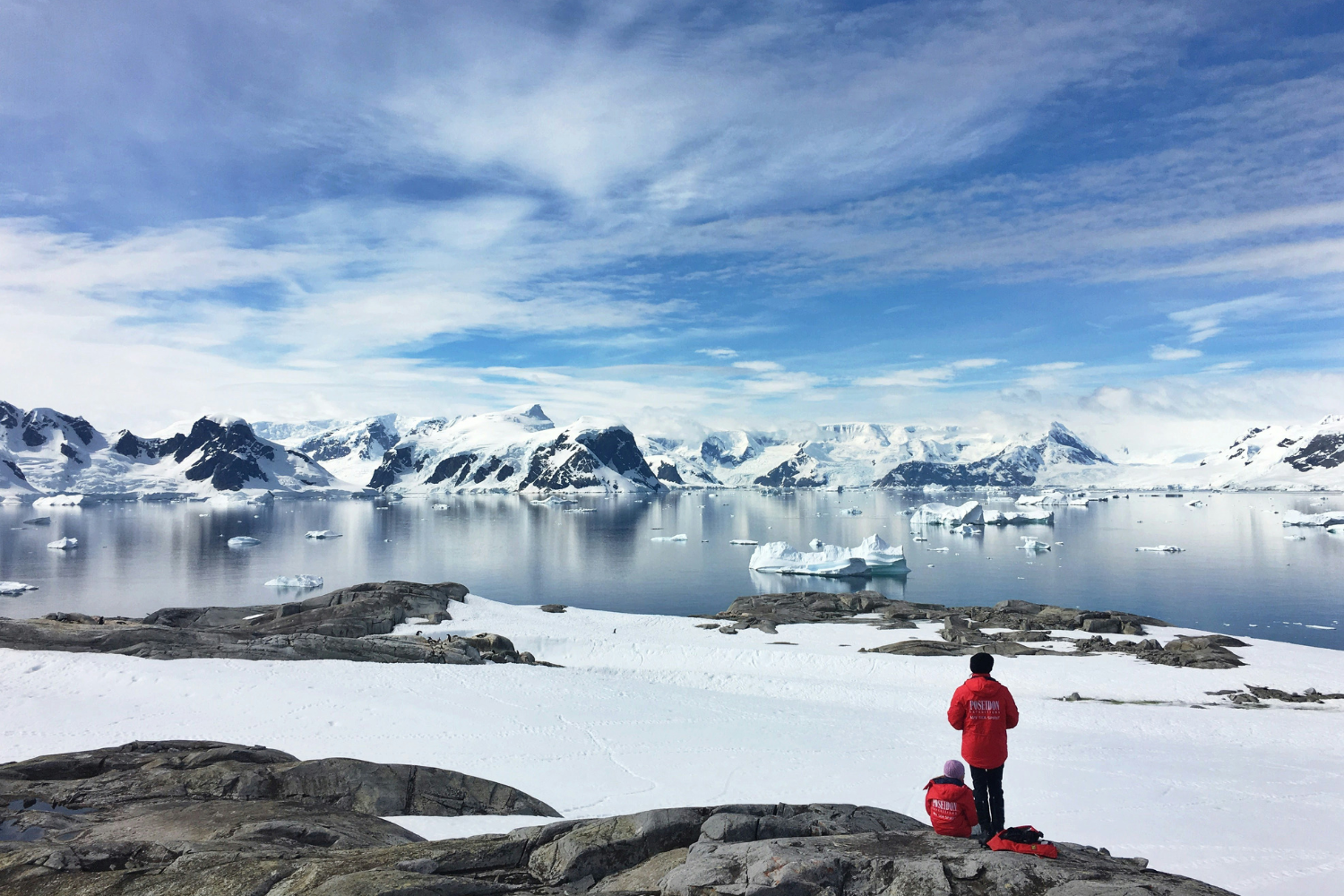 Two travellers sitting looking out at Antarctica views