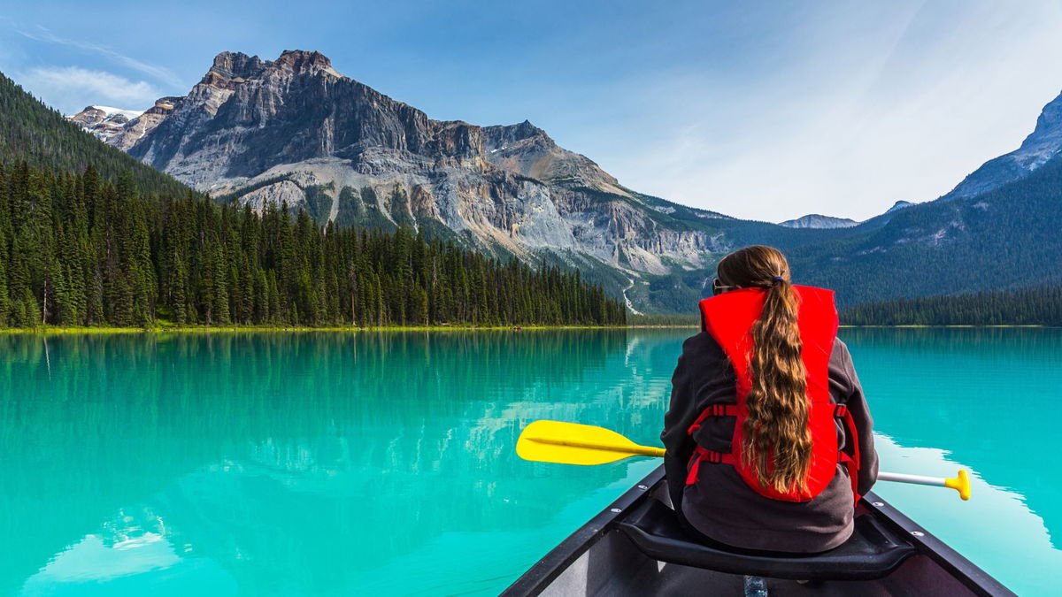 Traveller kayaking on lake in Canada