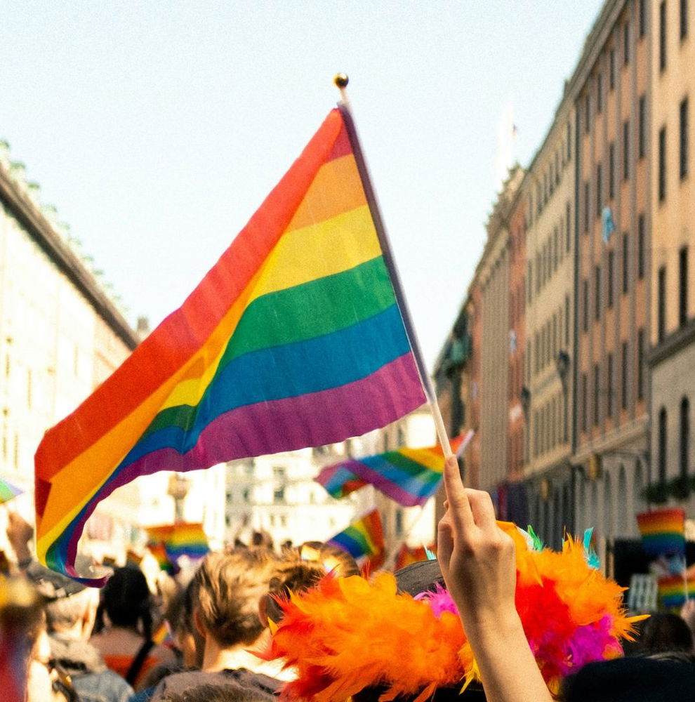 People with rainbow flags celebrating Pride in street in Europe