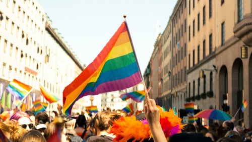 People with rainbow flags celebrating Pride in street in Europe