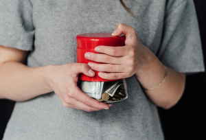 person holding a jar of money