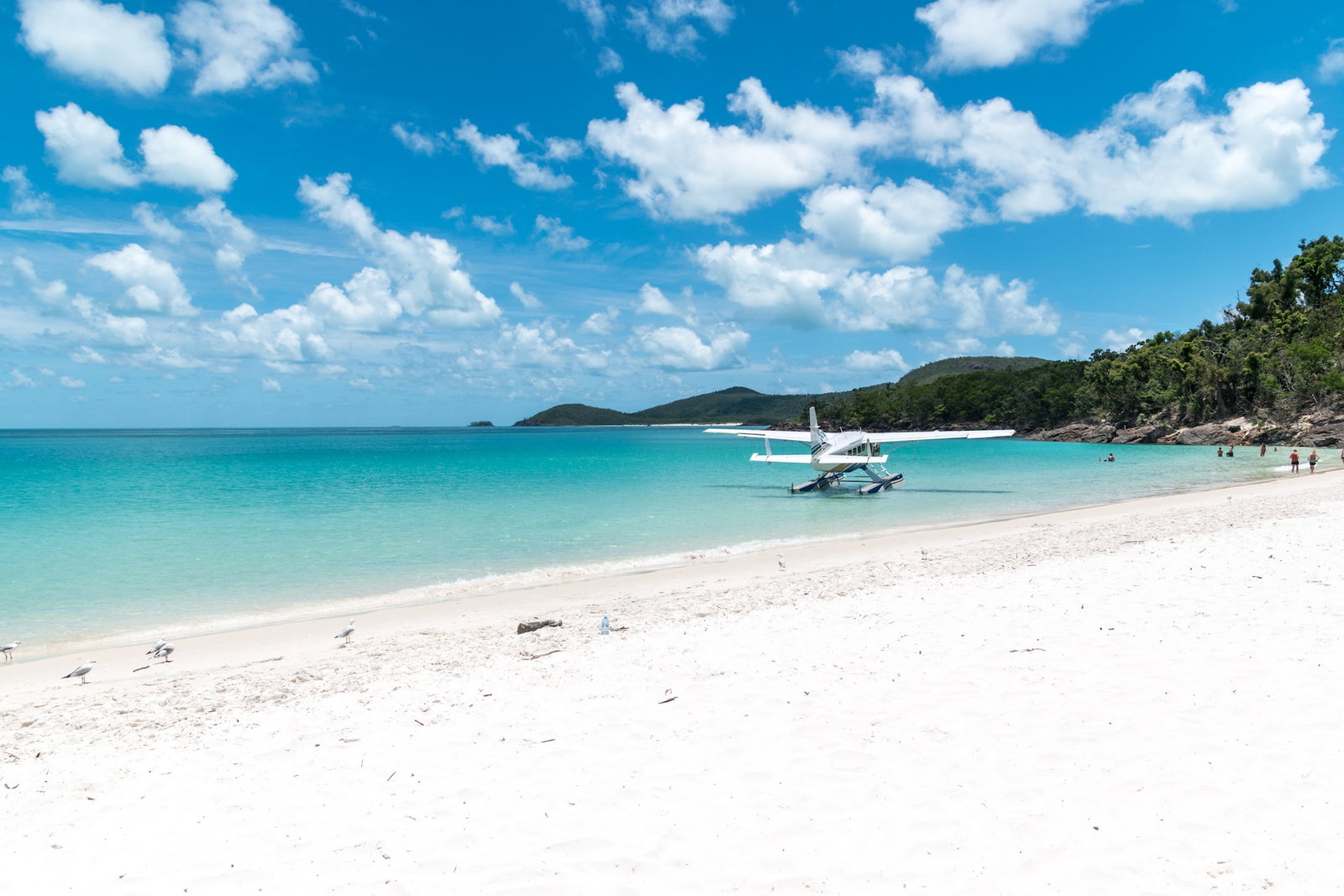 A catamaran on a beach with pristine white sand and blue water