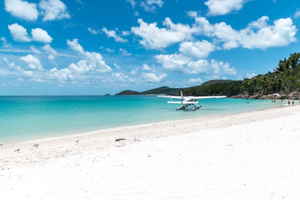A catamaran on a beach with pristine white sand and blue water